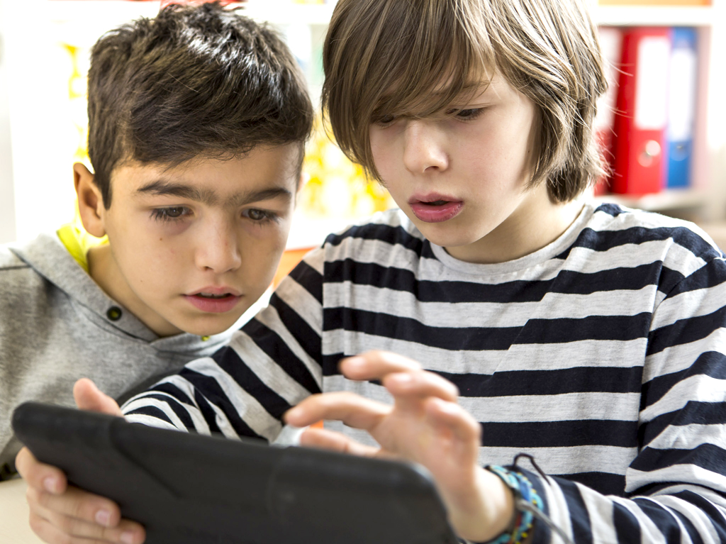 Zwei Jungen schauen auf ein Tablet