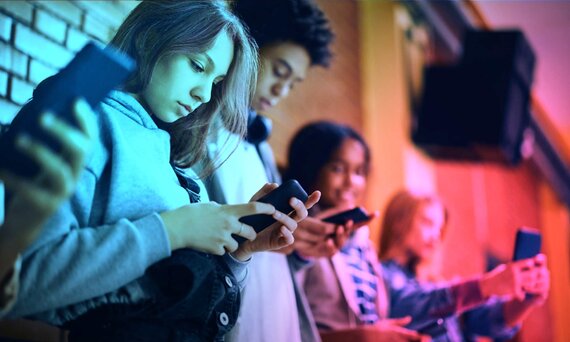 Mehrere Jugendliche nutzen ihre Smartphones