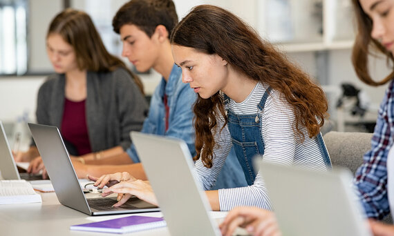 Bild von Jugendlichen, die konzentriert am Laptop sitzen