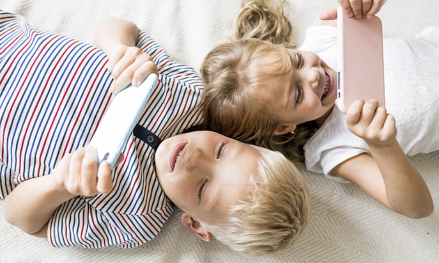 Zwei Kinder schauen auf Tablets