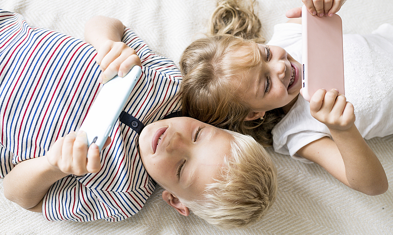 Zwei Kinder schauen auf Tablets