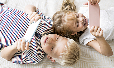 Zwei Kinder schauen auf Tablets