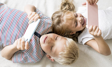 Zwei Kinder schauen auf Tablets