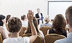 Eine junge Frau meldet sich in einem Seminar zu Wort