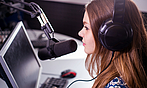 Foto einer jungen Frau bei der Radio-Moderation