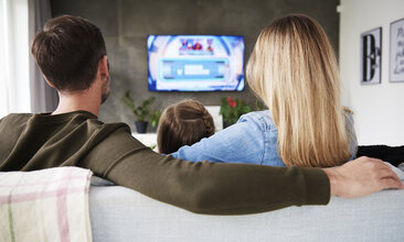 Foto einer Familie vor dem Fernseher